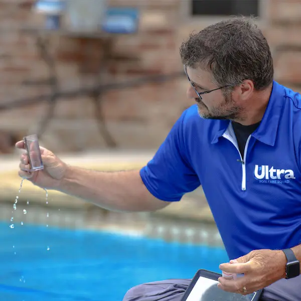 An Ultra Pool Care Squad technician performing a swimming pool water test