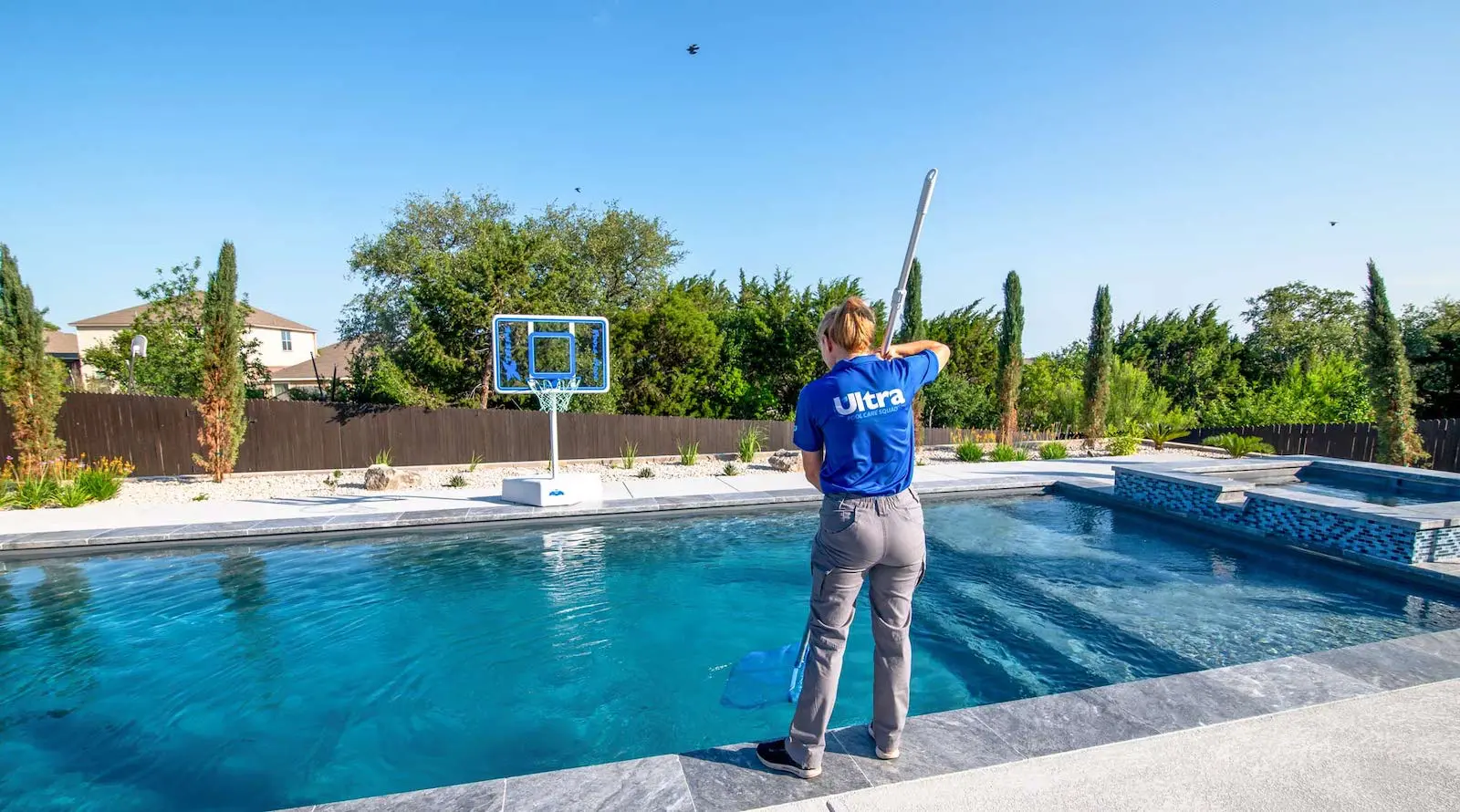 An Ultra Pool Care Squad technician cleaning a pool
